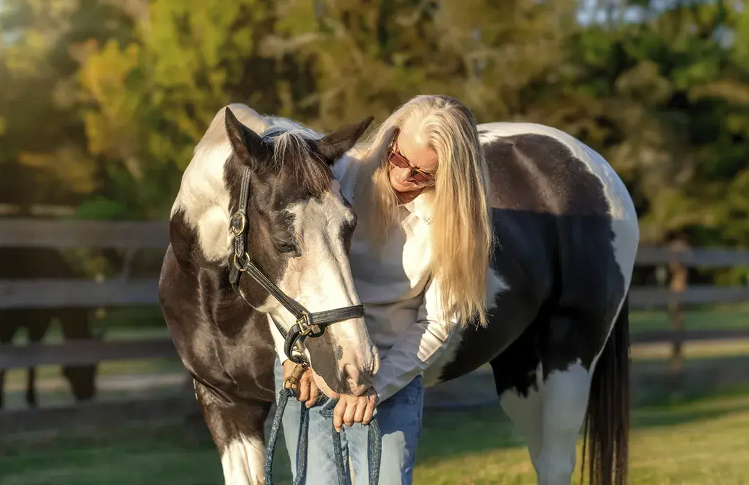 Equine Program Manager Kristi Venezia with a pinto horse